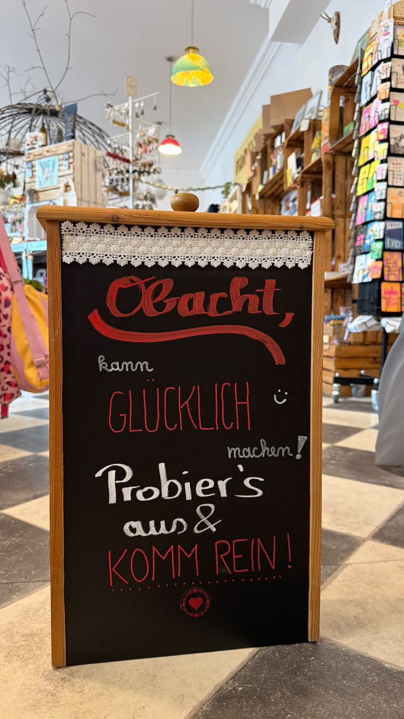 Kreidetafel im Laden: Obacht, kann glücklich machen! Probier's aus und komm rein!
